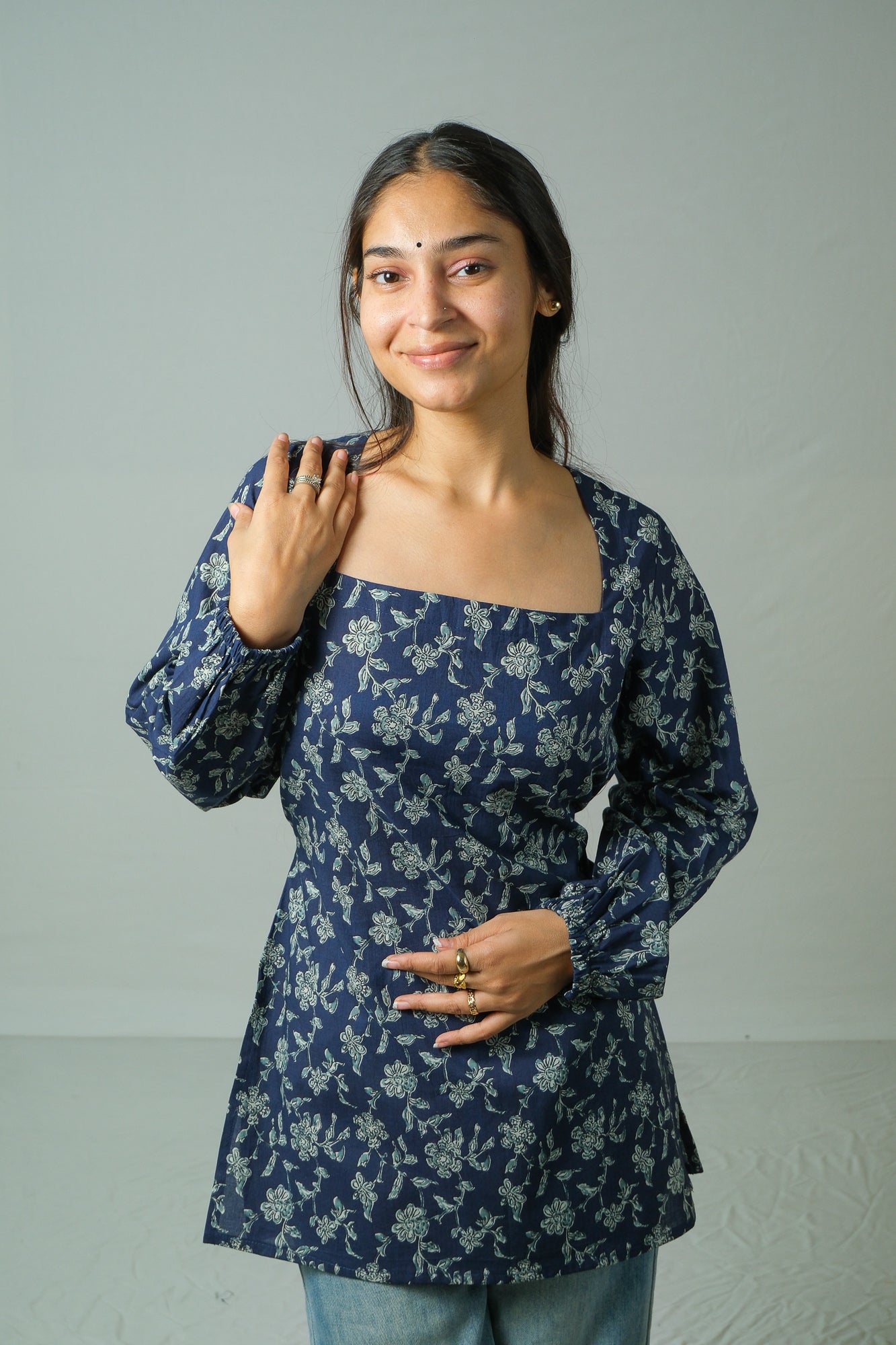 Woman wearing a blue floral top against a plain background